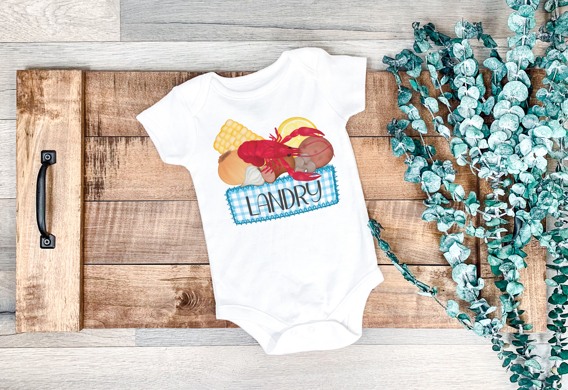 Personalized crawfish boil onesie with a pink gingham name plate for baby's name.