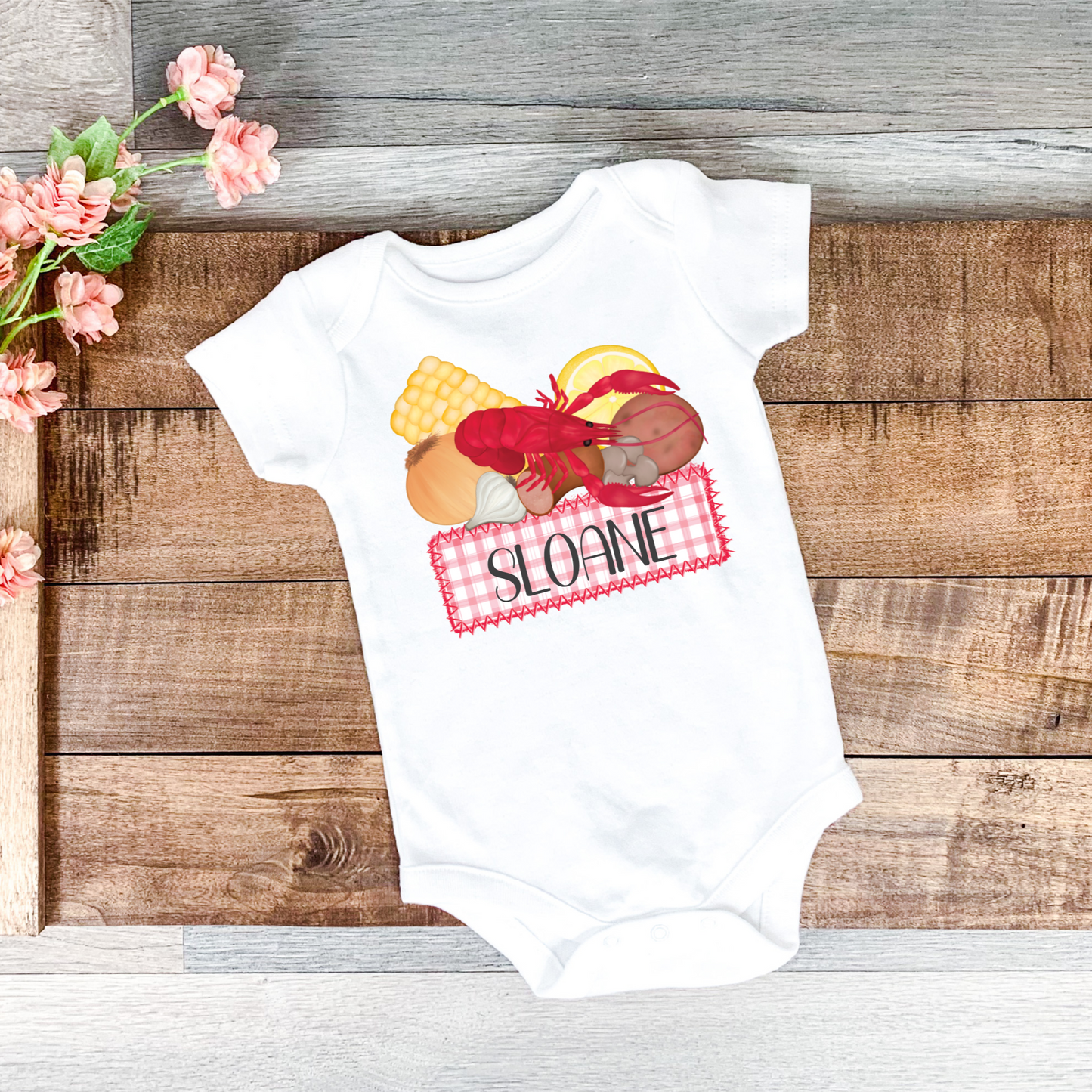 Personalized crawfish boil onesie with a pink gingham name plate for baby's name.